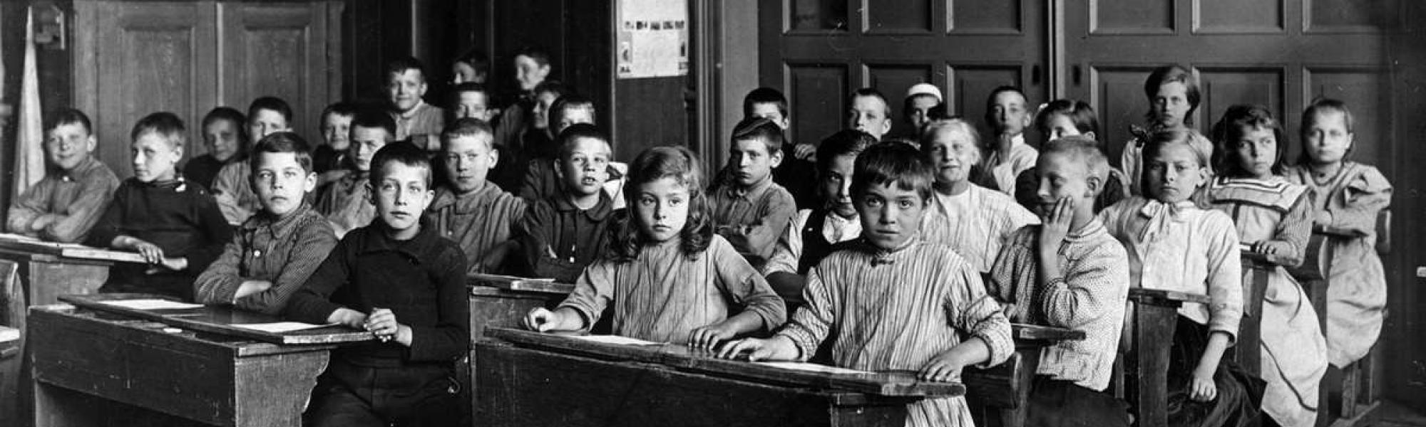 Historisch beeld van een klaslokaal met schoolkinderen